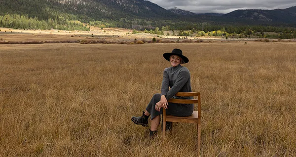 Woman sitting on chair in field during Fall.